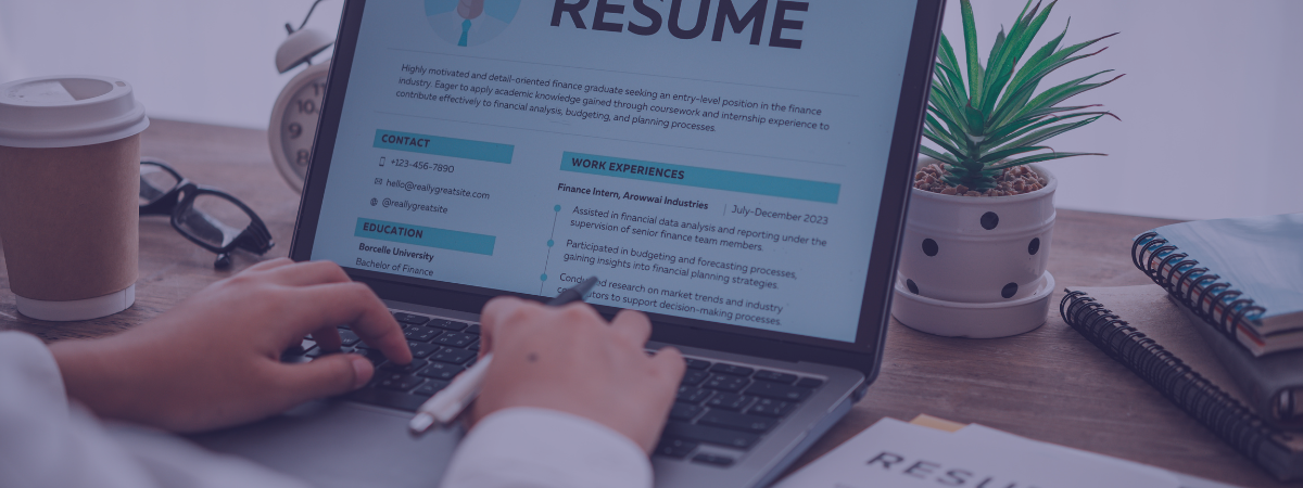 A person works on their resume on a laptop.