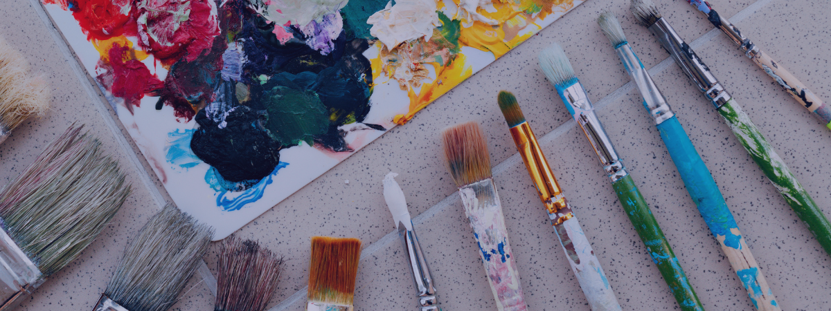 Paint brushes and a palette on a table.