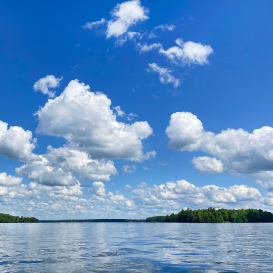 Balsam Lake on a sunny day with blue sky and clouds.